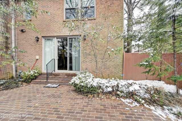 exterior space featuring brick siding, fence, and a patio