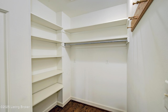 walk in closet with dark wood-type flooring