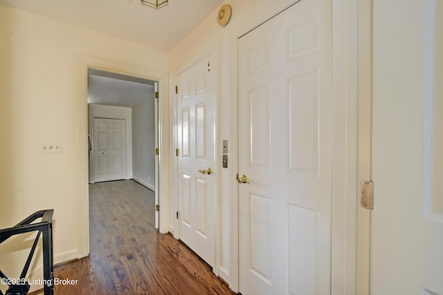 hallway with baseboards and dark wood-type flooring