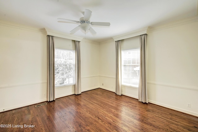 spare room featuring baseboards, dark wood finished floors, a ceiling fan, and crown molding