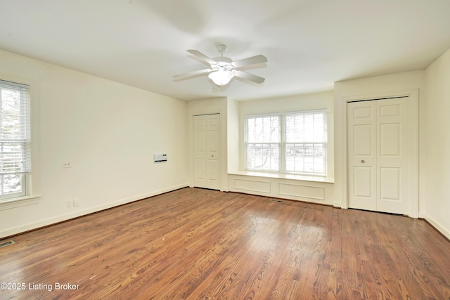 unfurnished room featuring a ceiling fan, visible vents, baseboards, and wood finished floors