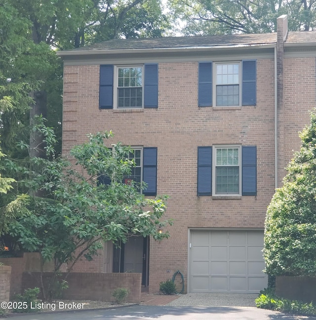 422 Sprite Rd Unit 1, Louisville, KY 40207 - view of front of home featuring an attached garage, brick siding, and driveway