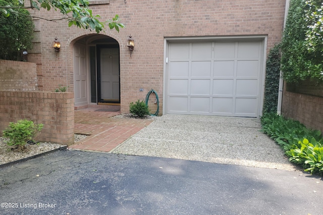 422 Sprite Rd Unit 1, Louisville, KY 40207 - view of exterior entry featuring driveway, a garage, and brick siding
