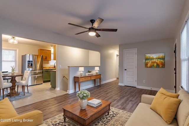 living room featuring ceiling fan, light hardwood / wood-style flooring, and sink