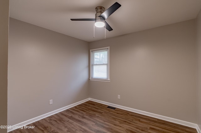 spare room with ceiling fan and dark wood-type flooring