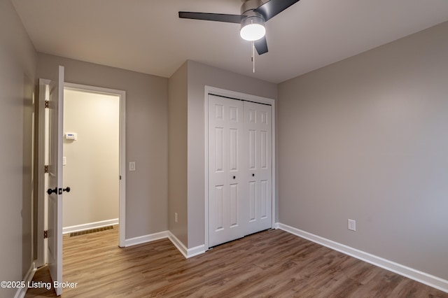 unfurnished bedroom featuring ceiling fan, a closet, and light hardwood / wood-style floors