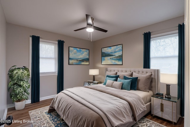 bedroom with multiple windows, hardwood / wood-style flooring, and ceiling fan