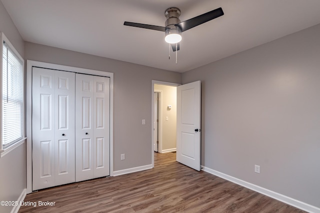 unfurnished bedroom with ceiling fan, wood-type flooring, and a closet