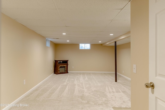 basement featuring carpet floors and a paneled ceiling