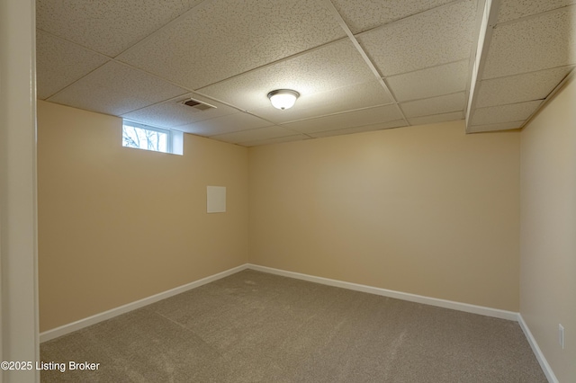 basement with a drop ceiling and carpet flooring