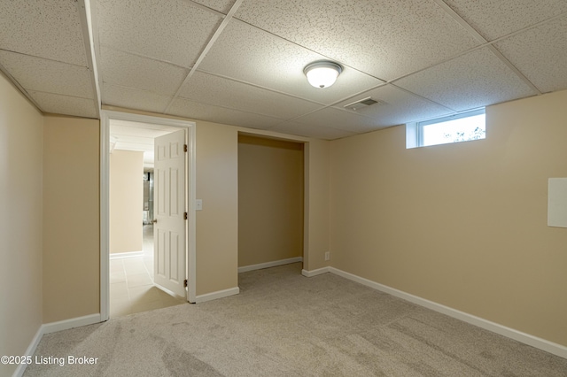 basement with carpet and a paneled ceiling