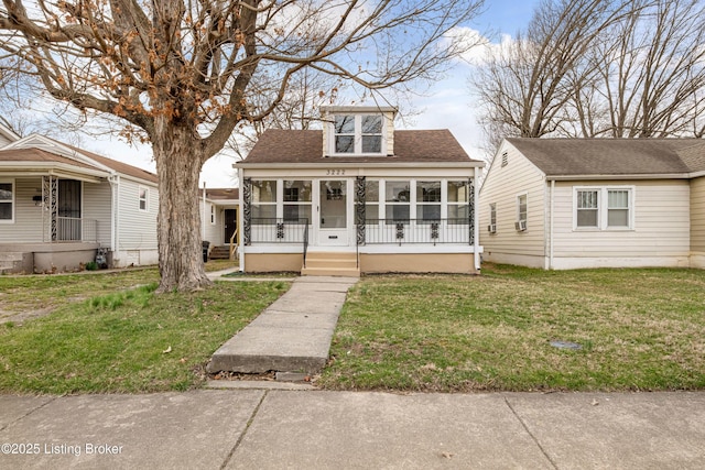 bungalow-style house with a sunroom, a porch, a front lawn, and a shingled roof