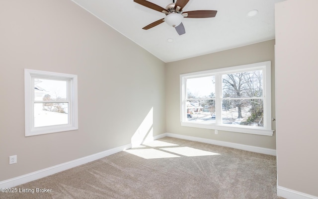 carpeted empty room featuring ceiling fan, high vaulted ceiling, and a wealth of natural light