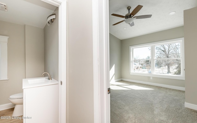 bathroom featuring ceiling fan, vanity, vaulted ceiling, and toilet