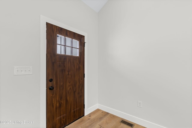 foyer featuring visible vents, light wood-style flooring, and baseboards