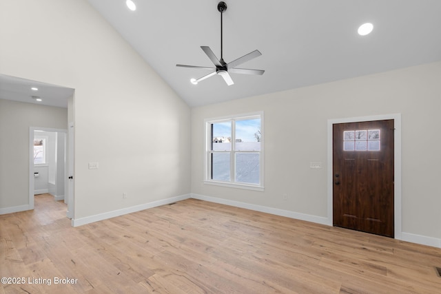 foyer entrance with a ceiling fan, baseboards, high vaulted ceiling, and light wood finished floors