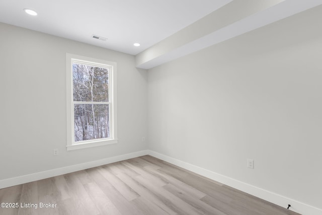 unfurnished room with recessed lighting, visible vents, light wood finished floors, and baseboards