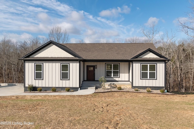 modern farmhouse style home with board and batten siding, a front yard, and roof with shingles