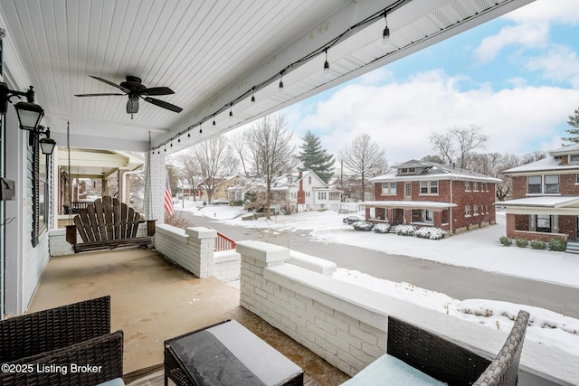 snow covered patio with covered porch and ceiling fan