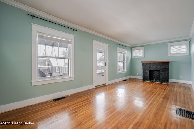 unfurnished living room featuring a fireplace, hardwood / wood-style flooring, and crown molding