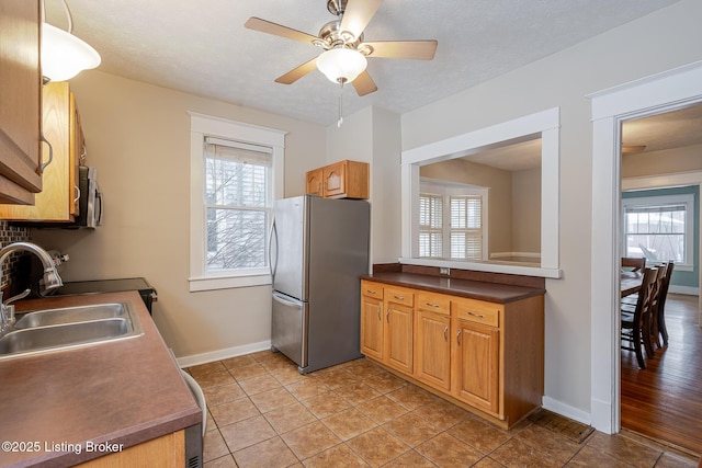 kitchen featuring ceiling fan, sink, stainless steel appliances, and a healthy amount of sunlight