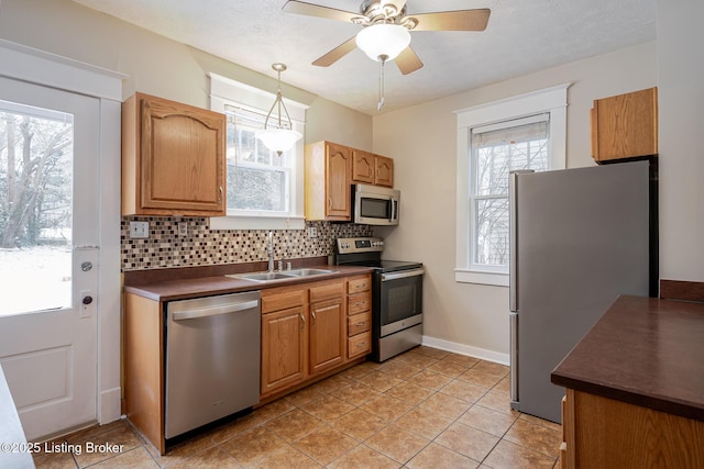 kitchen with decorative light fixtures, stainless steel appliances, backsplash, and sink