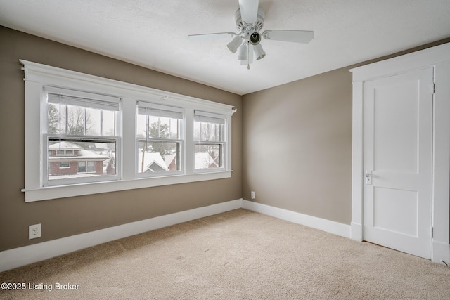 carpeted spare room with a textured ceiling and ceiling fan