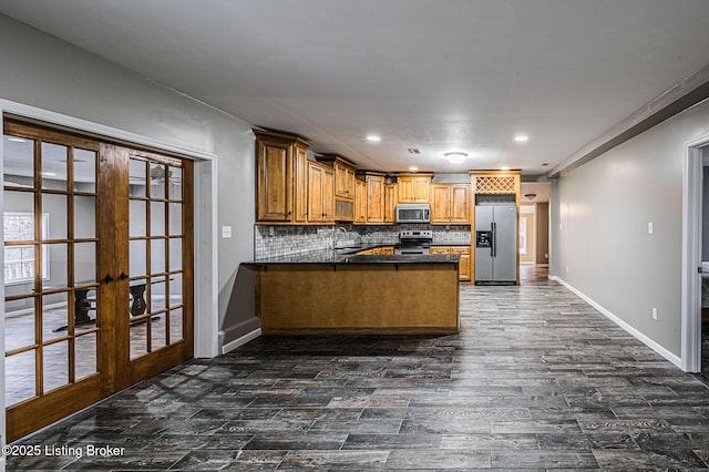 kitchen featuring appliances with stainless steel finishes, sink, kitchen peninsula, french doors, and decorative backsplash