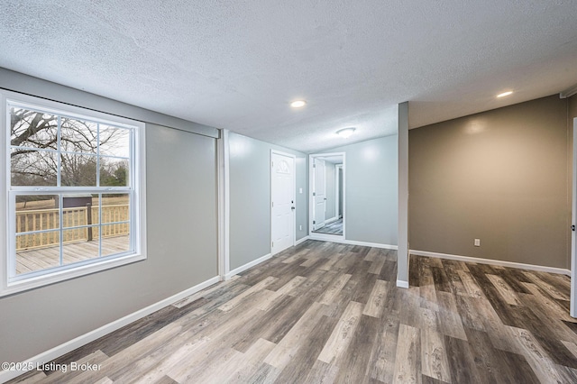 empty room with hardwood / wood-style flooring and a textured ceiling