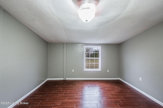 empty room featuring dark hardwood / wood-style flooring and a textured ceiling