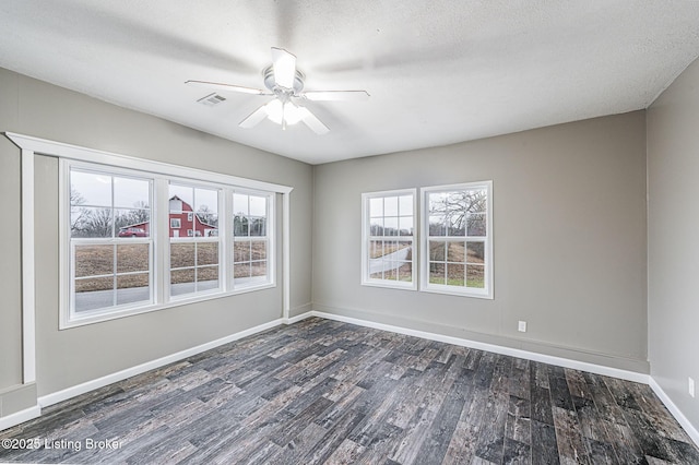 empty room featuring dark hardwood / wood-style flooring, ceiling fan, and a textured ceiling