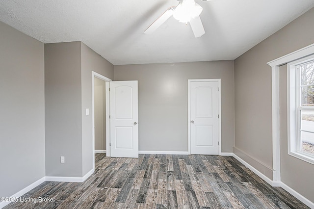 unfurnished bedroom featuring ceiling fan and dark hardwood / wood-style flooring