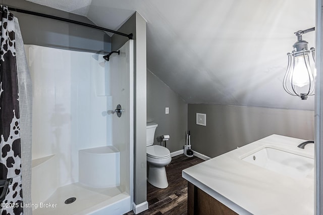 bathroom featuring hardwood / wood-style floors, vaulted ceiling, a shower with curtain, and vanity