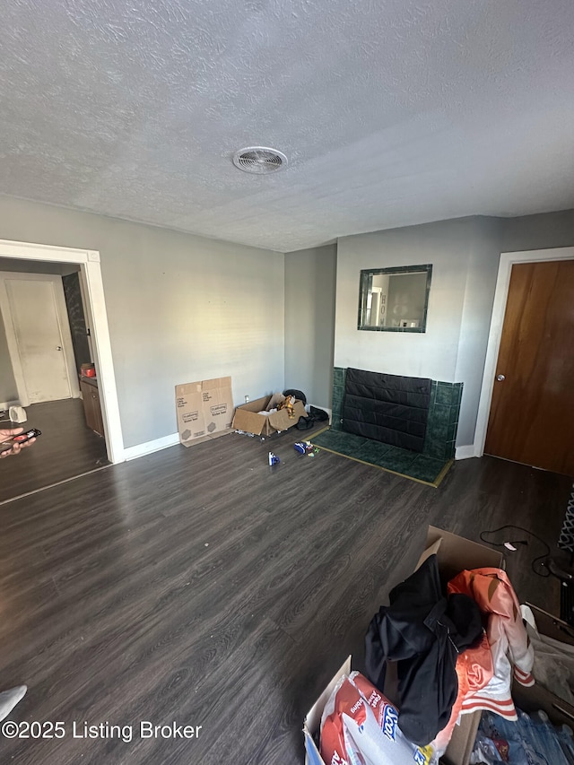 unfurnished living room featuring dark hardwood / wood-style floors and a textured ceiling