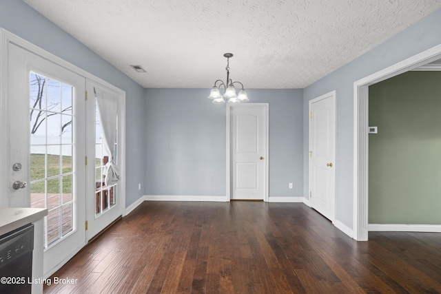 unfurnished dining area featuring dark wood-type flooring, a chandelier, a textured ceiling, and baseboards