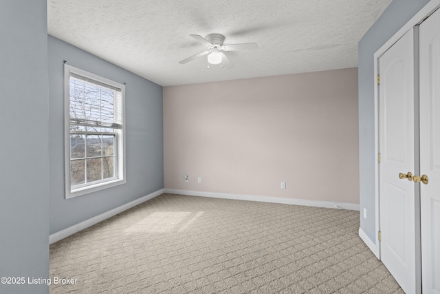 unfurnished bedroom featuring a textured ceiling, carpet flooring, a ceiling fan, and baseboards