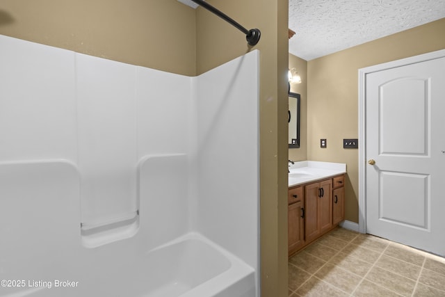 full bathroom featuring a textured ceiling, vanity, and tile patterned floors