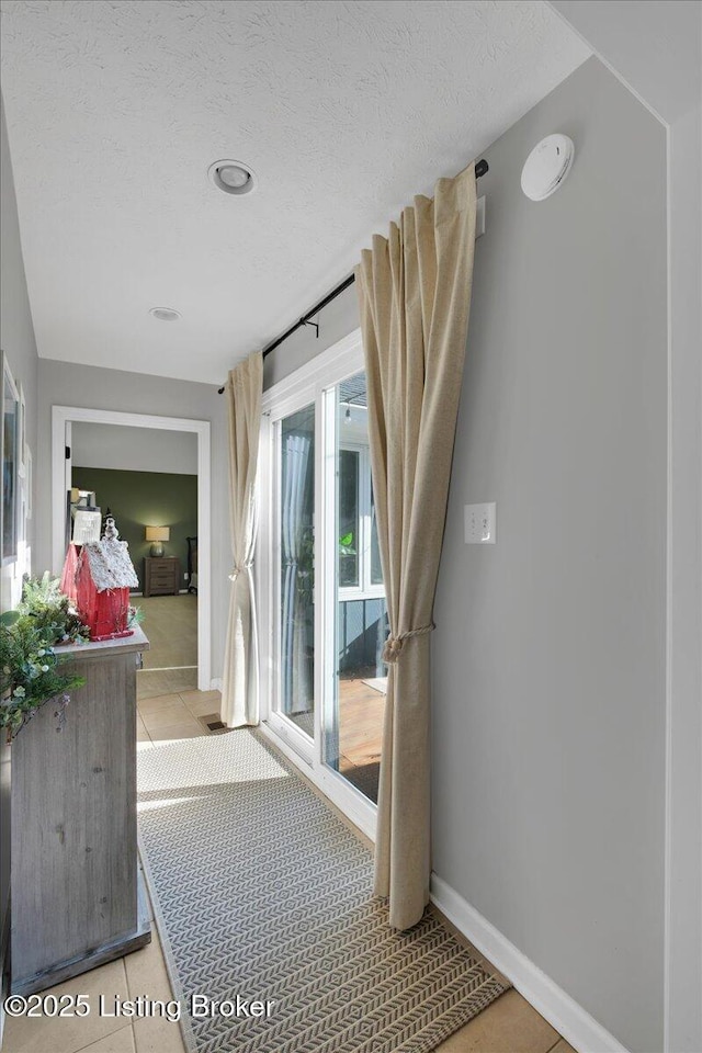 interior space featuring a textured ceiling and light tile patterned floors