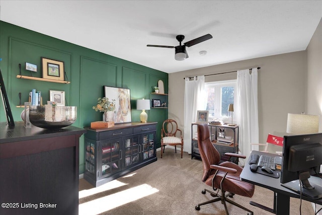 carpeted office space featuring ceiling fan