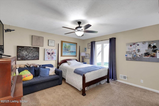 carpeted bedroom featuring a textured ceiling and ceiling fan