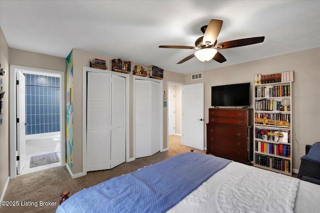 carpeted bedroom with ensuite bathroom, multiple closets, and ceiling fan