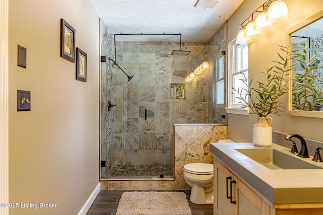 bathroom with a stall shower, visible vents, vanity, and toilet