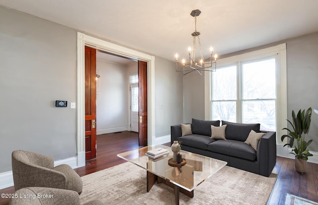 living room with dark hardwood / wood-style flooring and an inviting chandelier