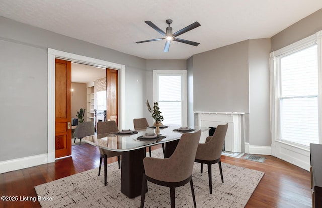 dining space with ceiling fan and dark hardwood / wood-style floors