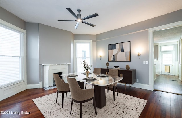 dining room with ceiling fan, dark hardwood / wood-style floors, and a wealth of natural light