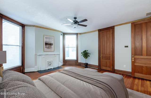 bedroom featuring ornamental molding, hardwood / wood-style floors, and ceiling fan