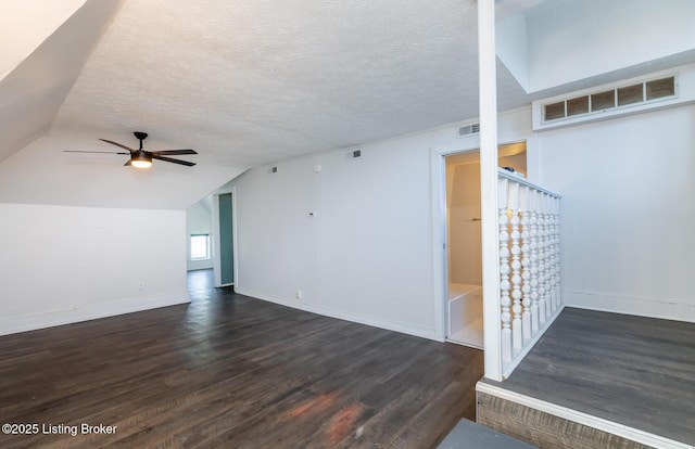 interior space with dark hardwood / wood-style flooring, a textured ceiling, and lofted ceiling