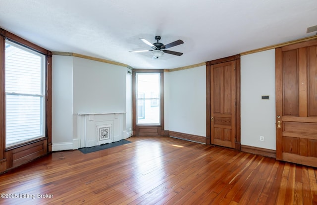 unfurnished living room with ceiling fan, dark wood-type flooring, and ornamental molding