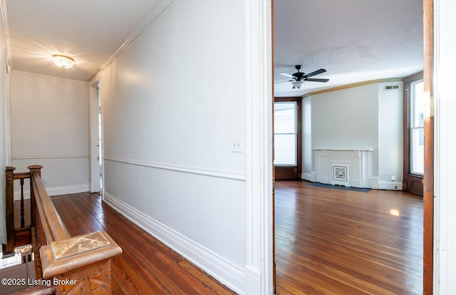 hall with dark wood-type flooring and crown molding