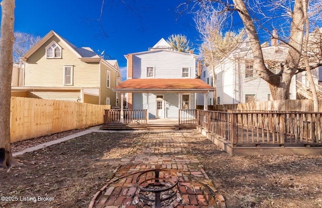 back of property featuring an outdoor fire pit and a deck